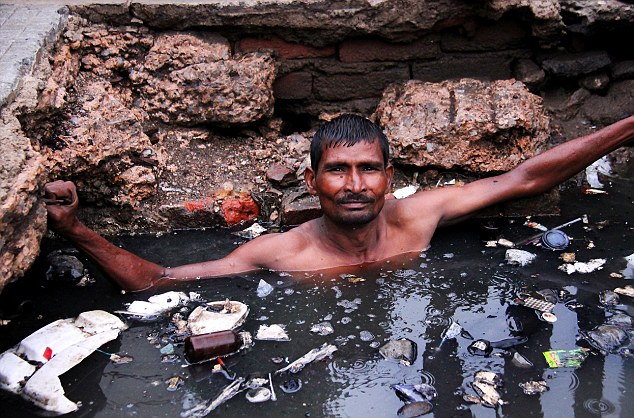 Indiano mergulha no esgoto e recebe R$ 9,50 por dia e uma garrafa de bebida alcoólica para trabalhar