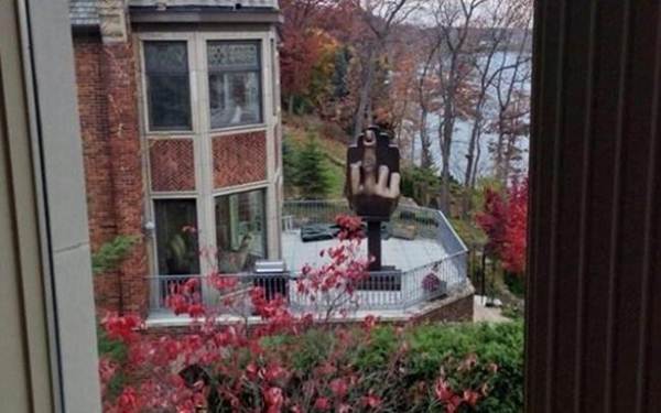Homem compra casa ao lado de ex-esposa e coloca dedo médio gigante no quintal